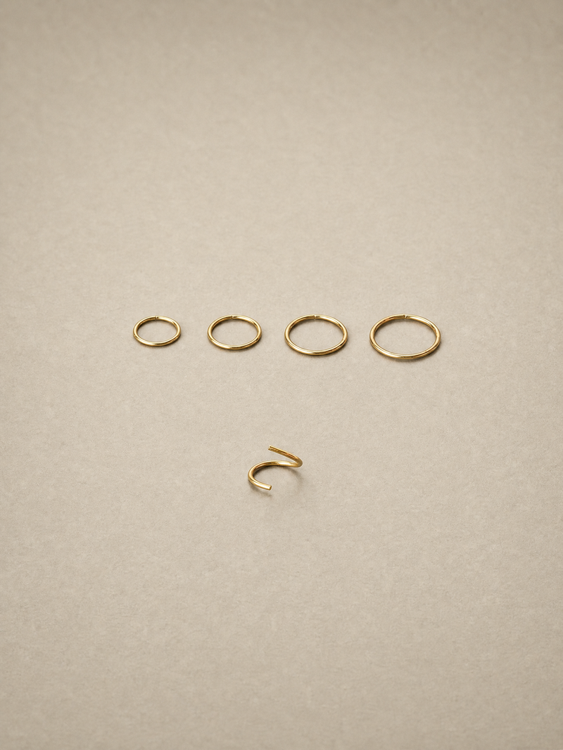 Set of 14ct gold ear seamless ring on a beige background
