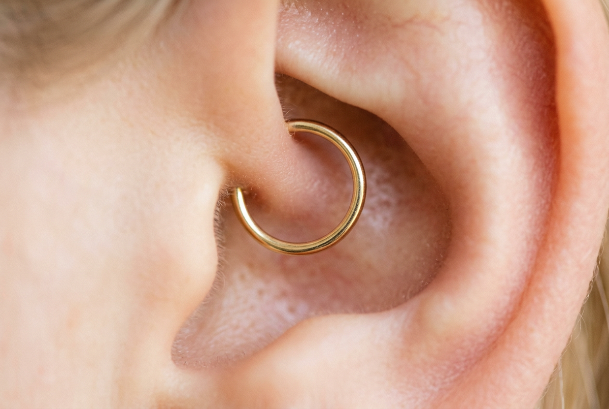 14K gold seamless hoop in a daith piercing, close-up showing the ring nestled in the inner ear fold