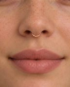 A delicate 14ct solid gold seamless septum hoop with a hand-hammered lower half. Choose 16G or 18G in yellow, white or rose gold. Handmade to order.
