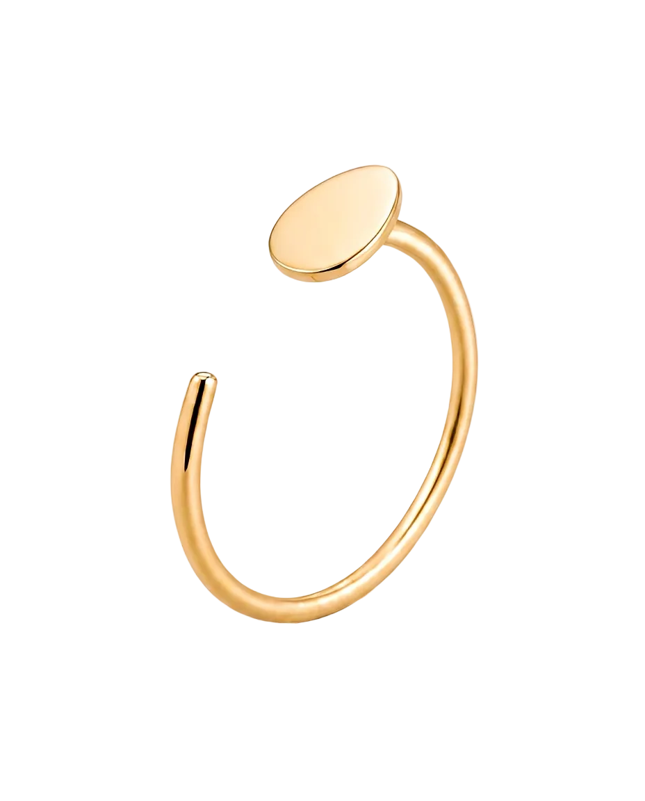 A minimalist gold open cuff ring with a flat, oval disc on one end, shown on a clean white background.