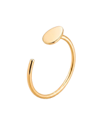 A minimalist gold open cuff ring with a flat, oval disc on one end, shown on a clean white background.
