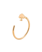 A gold open-ended ring featuring a small tree-shaped gold nose ring  at the top, displayed on a soft, light beige background.