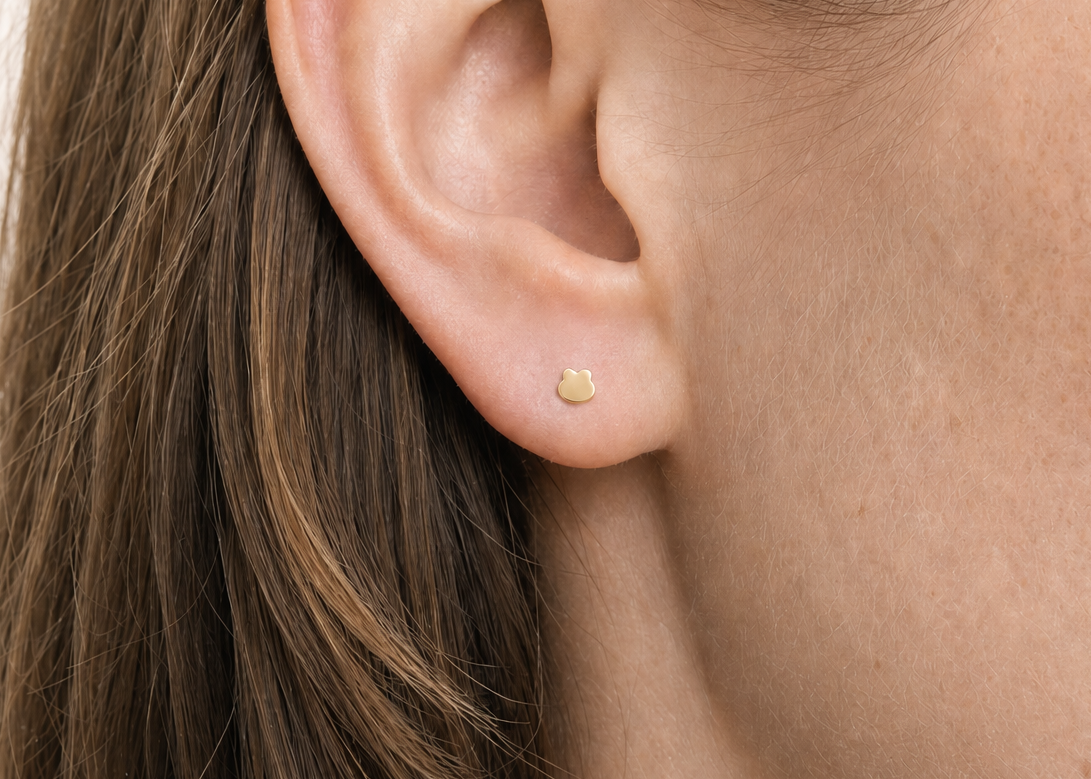 A playful 14ct solid gold Frog Hoop with a minimalist frog head and raised eye shapes. Available in 18G or 20G, 6–10mm, in three gold colours.