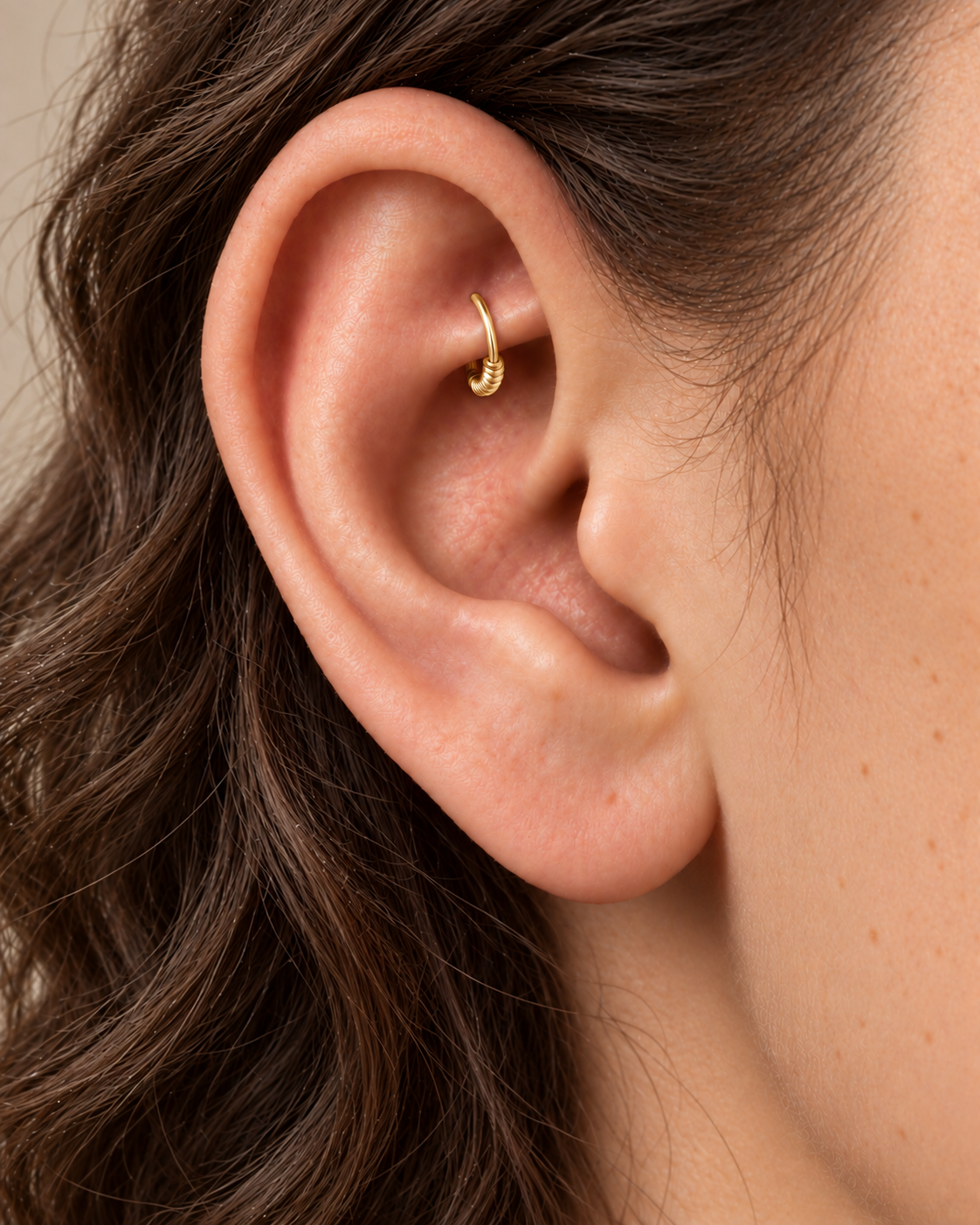A little detail, tucked beneath the inner fold. Solis brings a softly wrapped lower curve to a delicate 14ct solid gold rook ring. Fine gold wire is wound by hand around approximately half the hoop, while the upper arc stays smooth and polished.