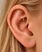 A little detail, tucked beneath the inner fold. Solis brings a softly wrapped lower curve to a delicate 14ct solid gold rook ring. Fine gold wire is wound by hand around approximately half the hoop, while the upper arc stays smooth and polished.