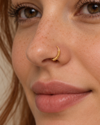 A little detail for your everyday nose ring. Solis brings a softly wrapped lower curve to a delicate 14ct solid gold nostril ring. Fine gold wire is wound by hand around approximately half the hoop, while the upper arc stays smooth and polished.
