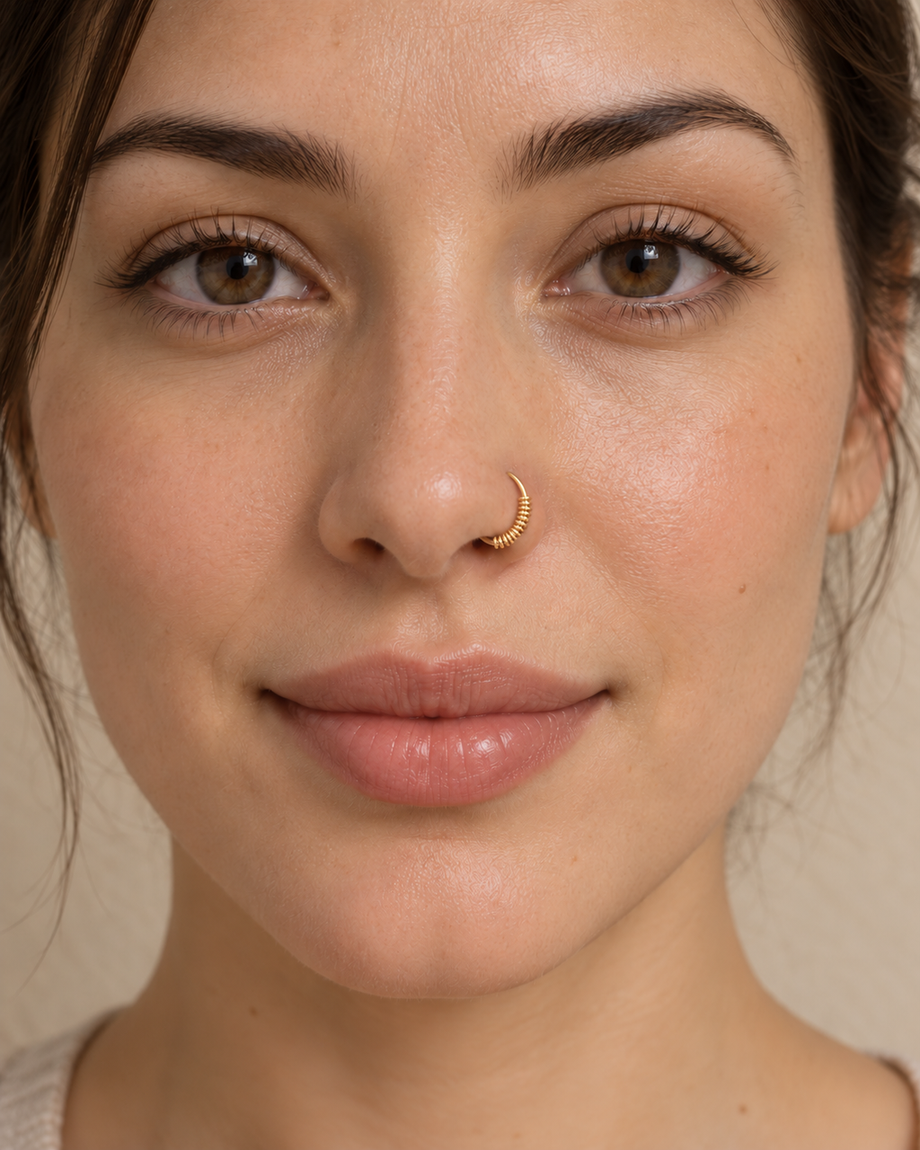 A little detail for your everyday nose ring. Solis brings a softly wrapped lower curve to a delicate 14ct solid gold nostril ring. Fine gold wire is wound by hand around approximately half the hoop, while the upper arc stays smooth and polished.
