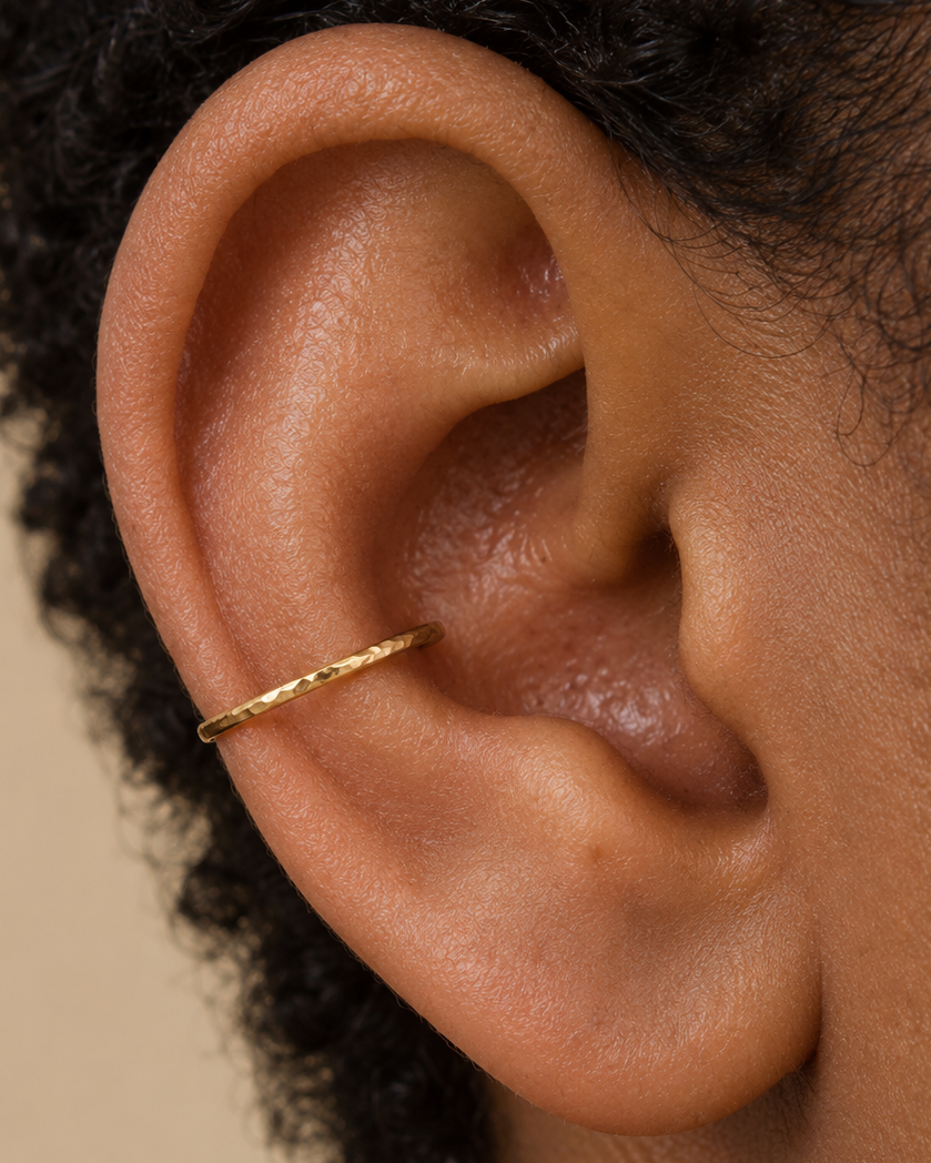 Discover Glimmer, a 14ct solid gold conch ring with a unique hand-hammered texture. Handmade to order in 10–15mm diameters, with a choice of 18G or 16G.
