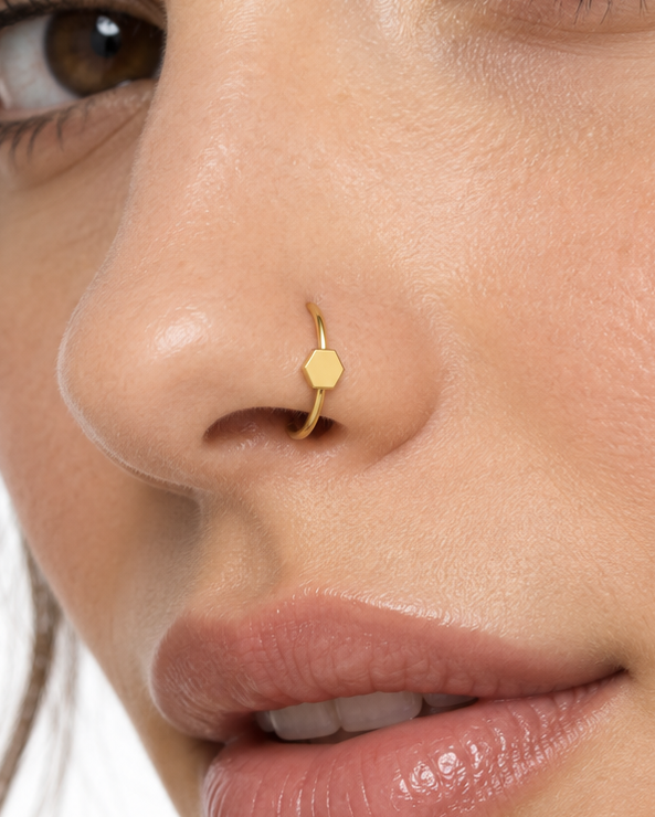 A small triangle gives the hoop a sharper geometric detail with a clean modern feel. Made for fully healed nostril piercings, the motif sits directly on a clean round hoop so the look stays neat rather than dangly. Handmade to order in 14ct solid gold, it fits naturally with clean, geometric and modern styling rather than reading as a generic plain hoop.