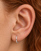 A familiar little hoop, with something extra to notice. Luma brings a softly shifting glow to a delicate 14ct solid gold earlobe hoop. The entire outer circumference is hammered by hand with tiny, irregular transverse marks: short strokes across the outer edge that catch the light in little flashes. The front-facing side and inner surface remain smooth and polished.

The width, depth, angle and spacing of these small marks vary naturally with each hammer stroke. No two rings have exactly the same pattern; y
