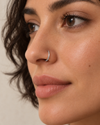A little light beside your smile. Luma brings a softly shifting glow to a delicate 14ct solid gold nostril ring. The entire outer circumference is hammered by hand with tiny, irregular transverse marks: short strokes across the outer edge that catch the light in little flashes. The front-facing side and inner surface remain smooth and polished.

The width, depth, angle and spacing of these small marks vary naturally with each hammer stroke. No two rings have exactly the same pattern; yours will share the de
