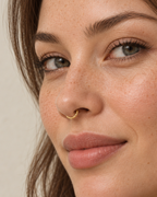 A little light beside your smile. Luma brings a softly shifting glow to a delicate 14ct solid gold nostril ring. The entire outer circumference is hammered by hand with tiny, irregular transverse marks: short strokes across the outer edge that catch the light in little flashes. The front-facing side and inner surface remain smooth and polished.

The width, depth, angle and spacing of these small marks vary naturally with each hammer stroke. No two rings have exactly the same pattern; yours will share the de