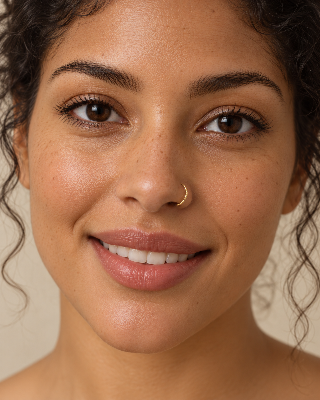 A little light beside your smile. Luma brings a softly shifting glow to a delicate 14ct solid gold nostril ring. The entire outer circumference is hammered by hand with tiny, irregular transverse marks: short strokes across the outer edge that catch the light in little flashes. The front-facing side and inner surface remain smooth and polished.

The width, depth, angle and spacing of these small marks vary naturally with each hammer stroke. No two rings have exactly the same pattern; yours will share the de