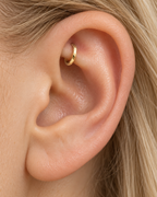 A quiet flash of gold in the upper fold of your ear. Luma brings a softly shifting glow to a delicate 14ct solid gold rook ring. The entire outer circumference is hammered by hand with tiny, irregular transverse marks: short strokes across the outer edge that catch the light in little flashes. The front-facing side and inner surface remain smooth and polished.