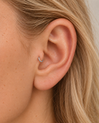 A tiny detail with a little light of its own. Luma brings a softly shifting glow to a delicate 14ct solid gold tragus ring. The entire outer circumference is hammered by hand with tiny, irregular transverse marks: short strokes across the outer edge that catch the light in little flashes. The front-facing side and inner surface remain smooth and polished.

The width, depth, angle and spacing of these small marks vary naturally with each hammer stroke. No two rings have exactly the same pattern; yours will s