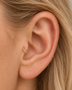 A tiny detail with a little light of its own. Luma brings a softly shifting glow to a delicate 14ct solid gold tragus ring. The entire outer circumference is hammered by hand with tiny, irregular transverse marks: short strokes across the outer edge that catch the light in little flashes. The front-facing side and inner surface remain smooth and polished.

The width, depth, angle and spacing of these small marks vary naturally with each hammer stroke. No two rings have exactly the same pattern; yours will s