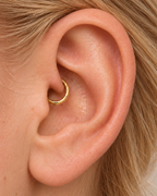 A small detail, tucked inside your ear. Ember brings a softly textured lower curve to a delicate 14ct solid gold daith ring. Its hand-hammered surface catches little flashes of light, while the upper arc stays smooth and polished.