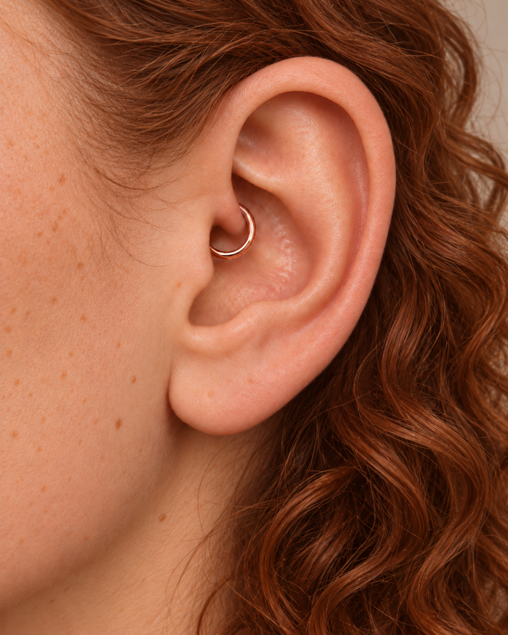 A small detail, tucked inside your ear. Ember brings a softly textured lower curve to a delicate 14ct solid gold daith ring. Its hand-hammered surface catches little flashes of light, while the upper arc stays smooth and polished.