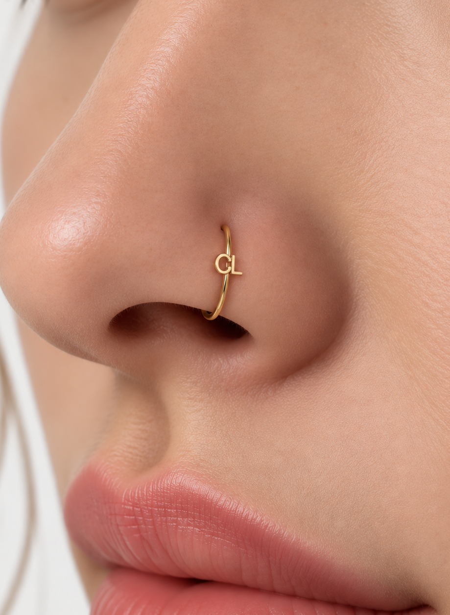 Choose two letters for a compact personalised motif that can represent initials without becoming oversized. Made for fully healed nostril piercings, the motif sits directly on a clean round hoop so the look stays neat rather than dangly. Handmade to order in 14ct solid gold, it fits naturally with personalised, meaningful and monogram-led styling rather than reading as a generic plain hoop.