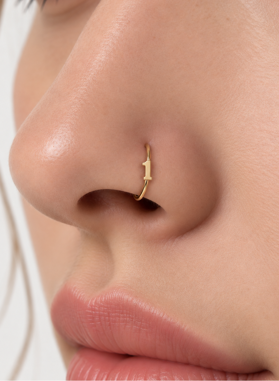 Choose one digit to give the hoop a small number-led detail with personal meaning. Made for fully healed nostril piercings, the motif sits directly on a clean round hoop so the look stays neat rather than dangly. Handmade to order in 14ct solid gold, it fits naturally with personalised, number-led and meaningful styling rather than reading as a generic plain hoop.