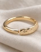 A delicate 14ct solid gold nose hoop with a widening hand-hammered detail. Handmade to order in your choice of diameter, gauge and yellow, white or rose gold.