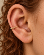 A smooth sweep, with a little detail at the edge. Solis brings a softly wrapped lower curve to a delicate 14ct solid gold conch ring. Fine gold wire is wound by hand around approximately half the hoop, while the upper arc stays smooth and polished.