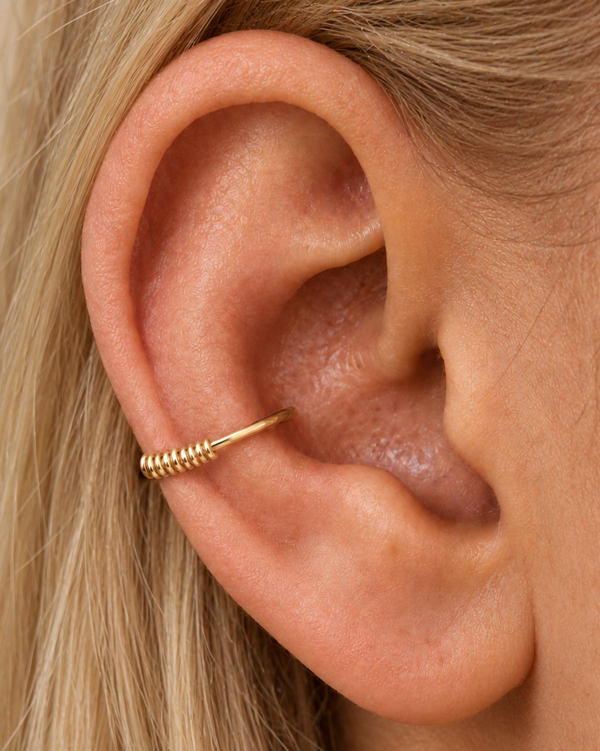A smooth sweep, with a little detail at the edge. Solis brings a softly wrapped lower curve to a delicate 14ct solid gold conch ring. Fine gold wire is wound by hand around approximately half the hoop, while the upper arc stays smooth and polished.