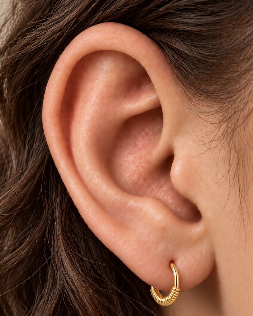 Your everyday gold hoop, with a little extra detail. Solis brings a softly wrapped lower curve to a delicate 14ct solid gold earlobe hoop. Fine gold wire is wound by hand around approximately half the hoop, while the upper arc stays smooth and polished.