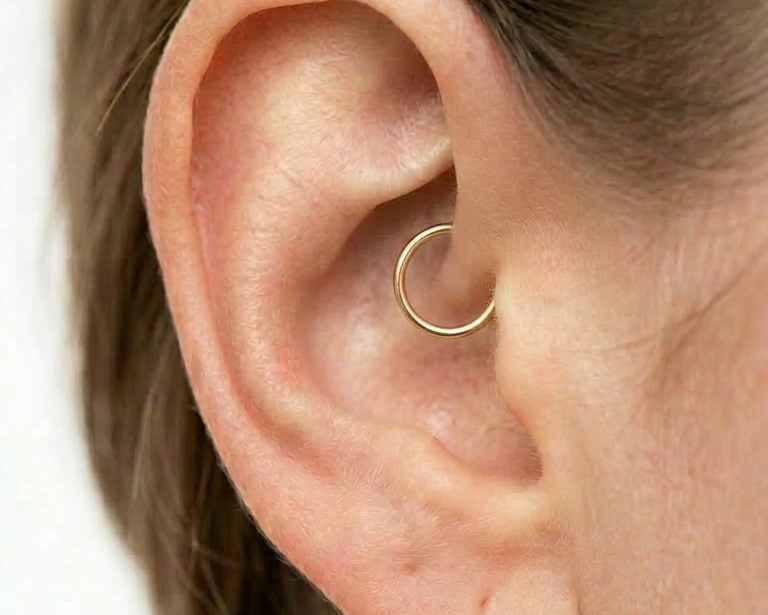 14K gold daith hoop earring close-up on ear