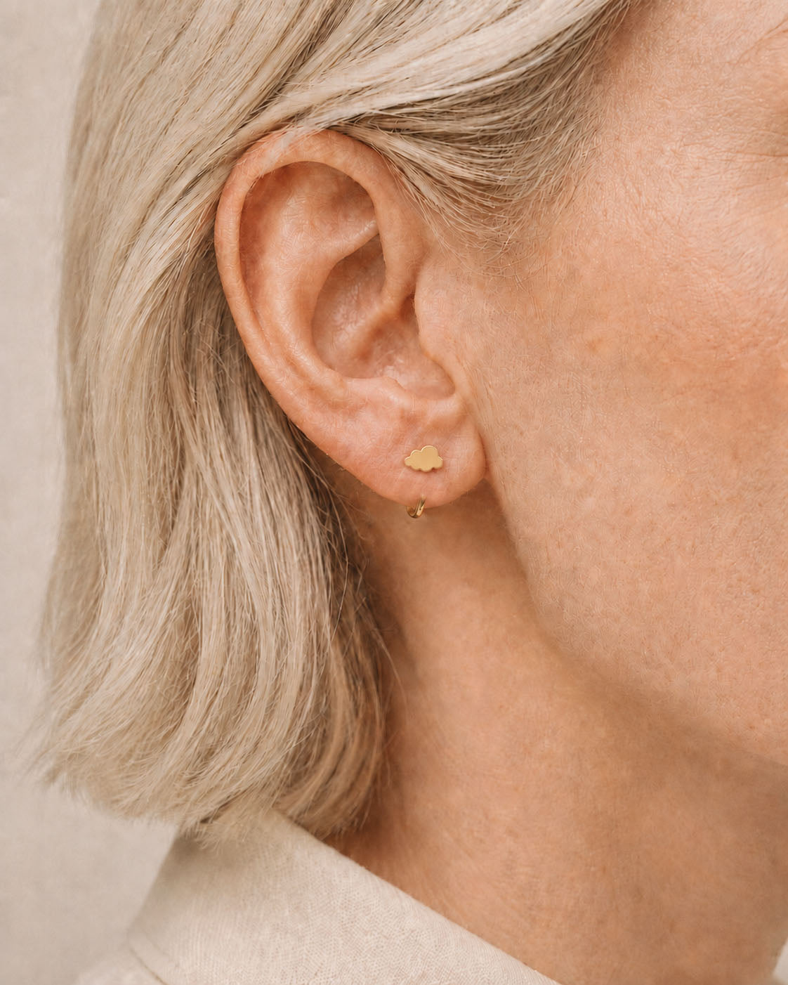A playful 14ct solid gold cloud huggie hoop with an open design for easier fitting. No twisting or end alignment required — simply guide the smooth end through your fully healed nose or ear piercing and rotate it into position.
