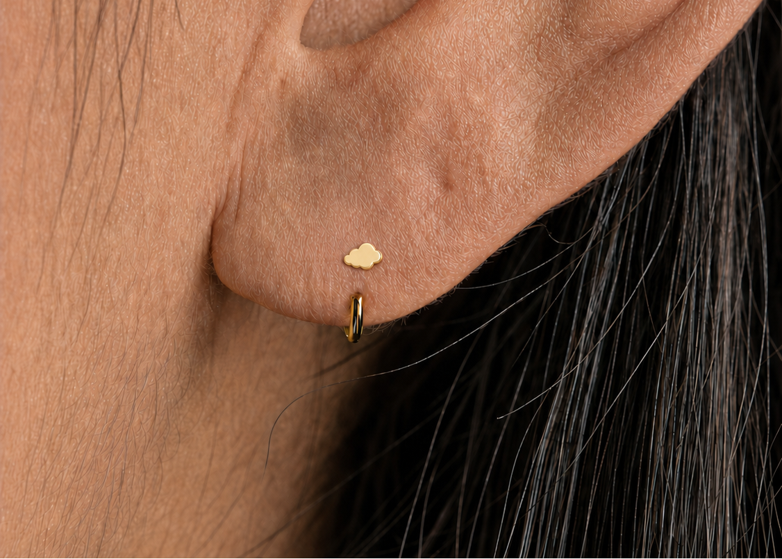A polished 14ct solid gold cloud on an easy-to-wear open hoop — dreamy, minimal and quietly playful.