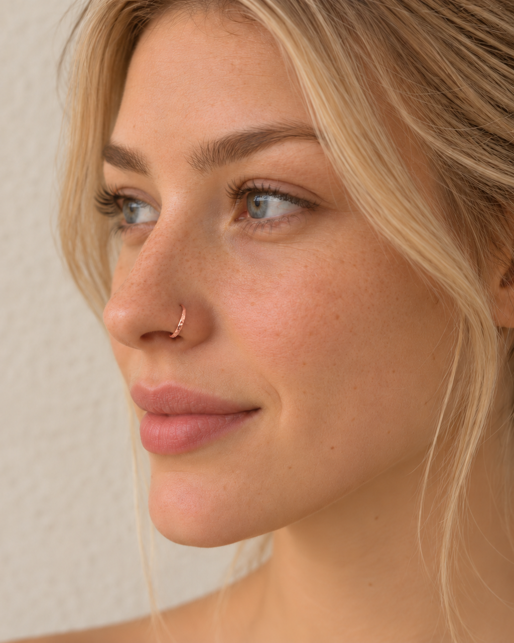 A delicate 14ct solid gold seamless nostril hoop with a hand-hammered outer curve. Made to order in 6–10mm, 18G or 20G, in yellow, white or rose gold.