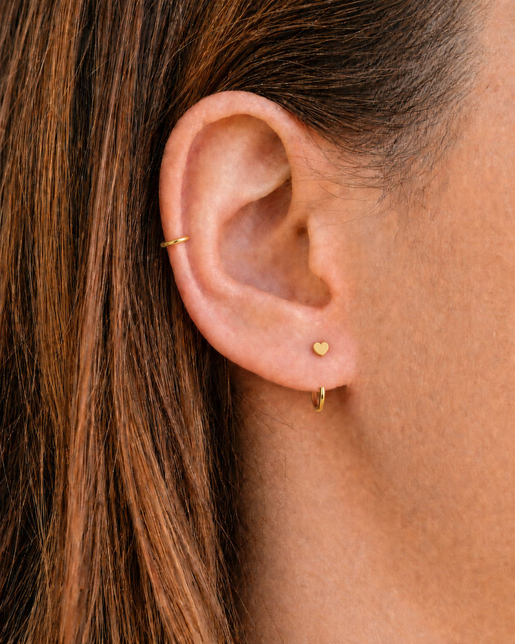 A timeless 14ct solid gold heart huggie hoop with an open design for easier fitting. No twisting or end alignment required — simply guide the smooth end through your fully healed nose or ear piercing and rotate it into position.