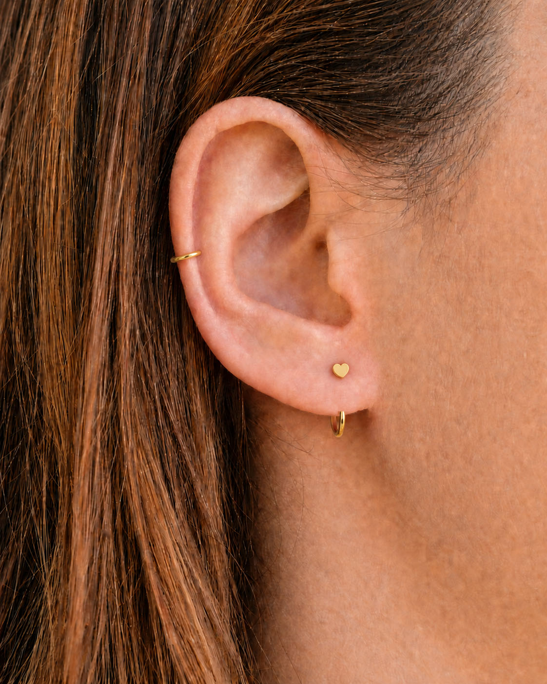 A timeless 14ct solid gold heart huggie hoop with an open design for easier fitting. No twisting or end alignment required — simply guide the smooth end through your fully healed nose or ear piercing and rotate it into position.