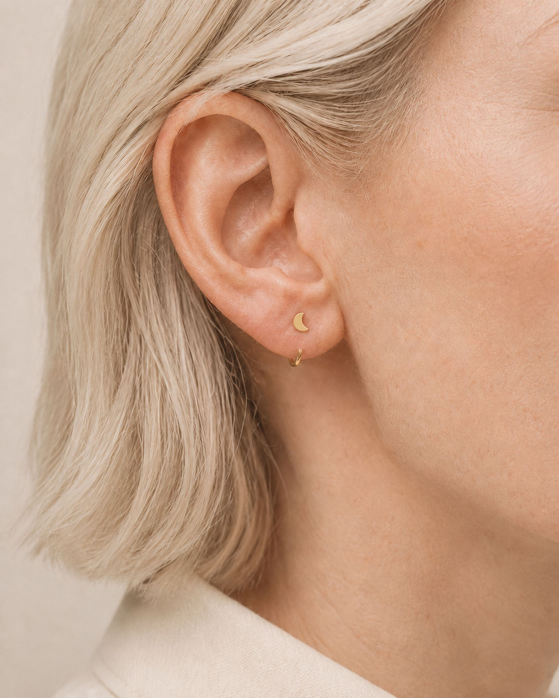 A celestial 14ct solid gold crescent moon huggie hoop with an open design for easier fitting. No twisting or end alignment required — simply guide the smooth end through your fully healed nose or ear piercing and rotate it into position.