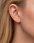 A playful 14ct solid gold star huggie hoop with an open design for easier fitting. No twisting or end alignment required — simply guide the smooth end through your fully healed nose or ear piercing and rotate it into position.