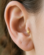A crisp little star adds a bright celestial point to an otherwise minimal gold hoop. Made for fully healed tragus piercings, it adds a compact decorative detail without turning the piece into a dangling design. Handmade to order in 14ct solid gold, it fits naturally with bright, celestial and playful styling rather than reading as a generic plain hoop.