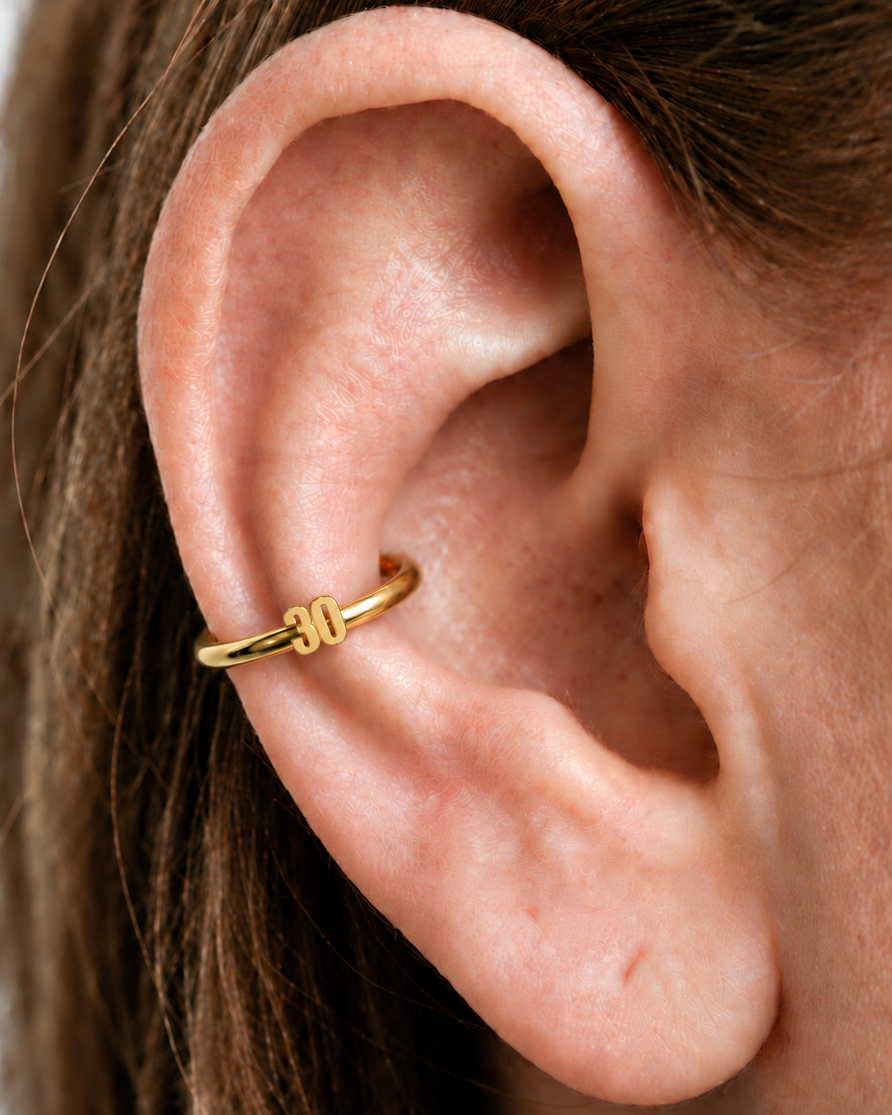 Choose a two-digit number from 10–99 for a more distinctive personalised detail. Made for fully healed conch piercings, it pairs the larger hoop silhouette of a conch ring with a small fixed motif for a more distinctive ear stack. Handmade to order in 14ct solid gold, it fits naturally with personalised, number-led and meaningful styling rather than reading as a generic plain hoop.
