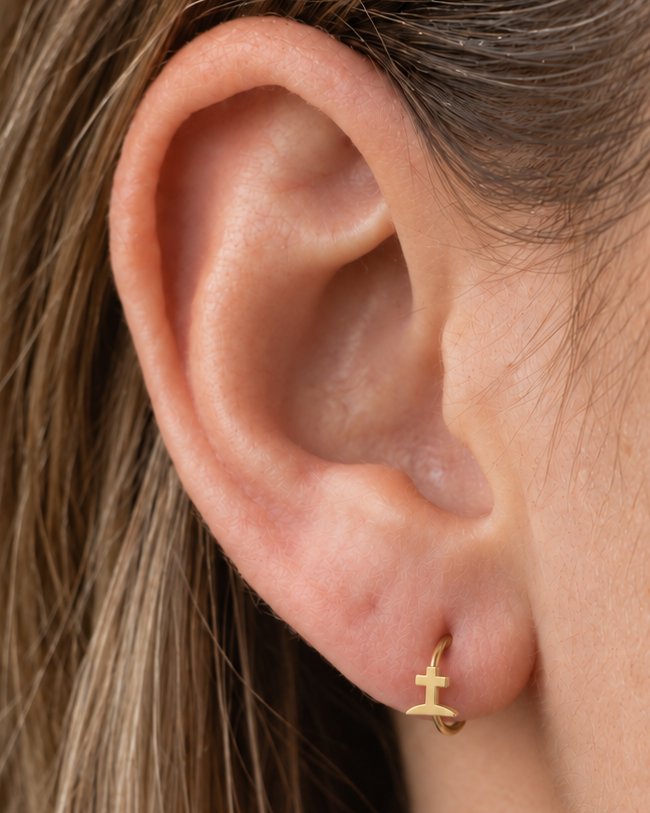 A graveyard-style cross gives the hoop a darker gothic reference that is distinct from the simpler cross design. Made for fully healed lobe piercings and sold individually, it works easily in first, second or third-lobe stacks. Handmade to order in 14ct solid gold, it fits naturally with gothic, spooky and alternative styling rather than reading as a generic plain hoop.