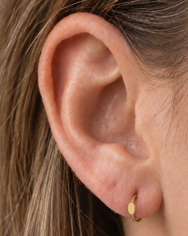 A polished oval adds a softer geometric detail for a clean, understated look. Made for fully healed lobe piercings and sold individually, it works easily in first, second or third-lobe stacks. Handmade to order in 14ct solid gold, it fits naturally with softly geometric and minimal styling rather than reading as a generic plain hoop.