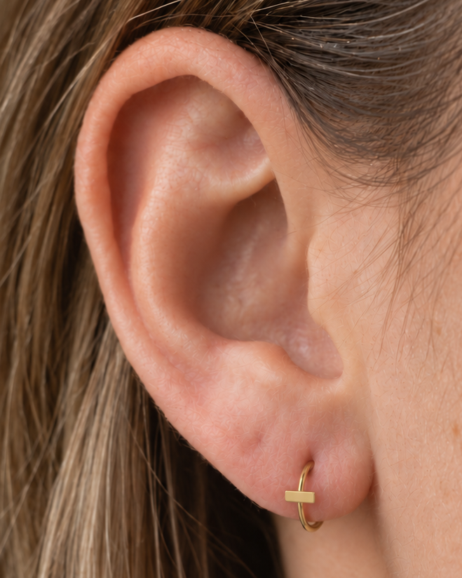 A slim bar creates a clean linear accent for a more modern, pared-back jewellery stack. Made for fully healed lobe piercings and sold individually, it works easily in first, second or third-lobe stacks. Handmade to order in 14ct solid gold, it fits naturally with linear, minimal and modern styling rather than reading as a generic plain hoop.