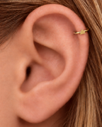 A small triangle gives the hoop a sharper geometric detail with a clean modern feel. Made for fully healed helix piercings, it keeps the profile compact for an upper-ear stack while leaving the motif clearly visible. Handmade to order in 14ct solid gold, it fits naturally with clean, geometric and modern styling rather than reading as a generic plain hoop.