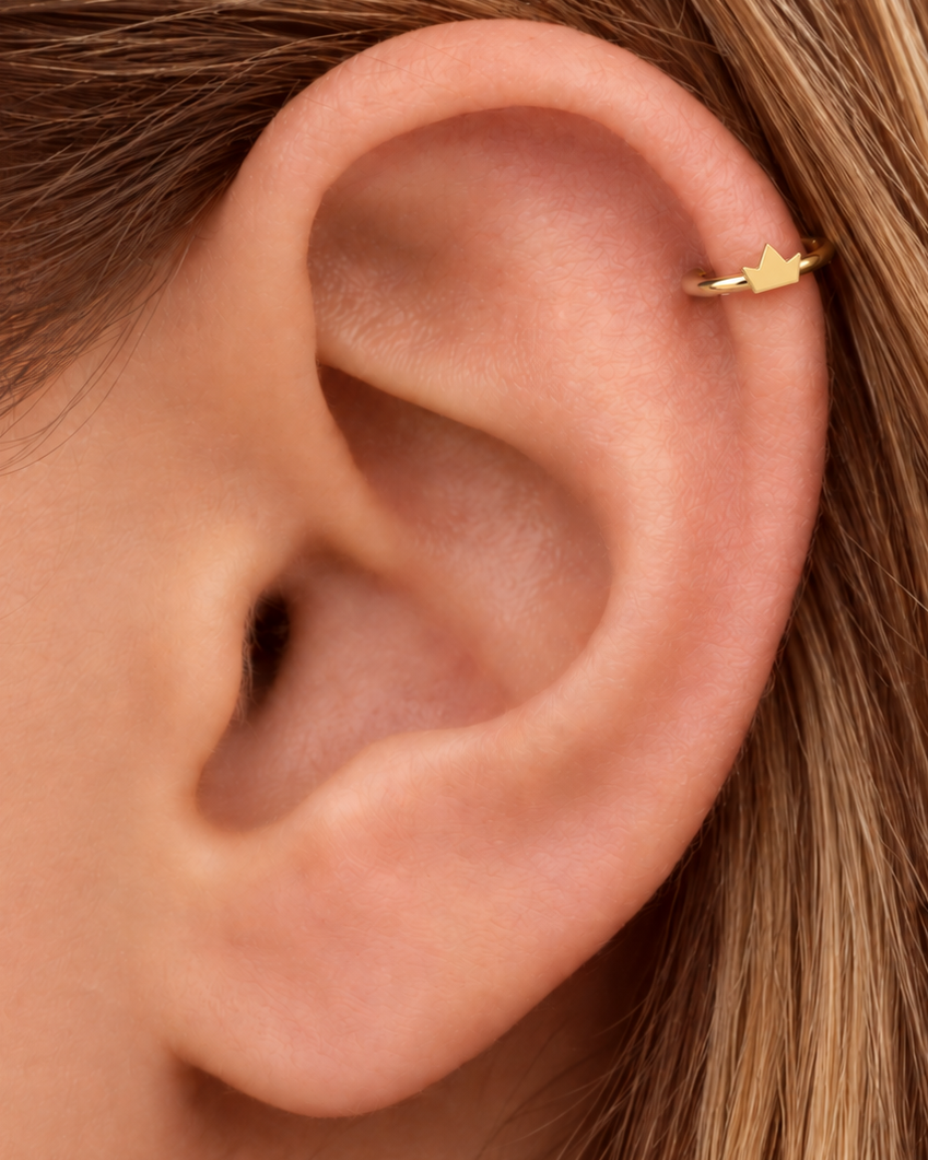 A tiny crown adds a playful statement detail while staying compact enough for everyday styling. Made for fully healed helix piercings, it keeps the profile compact for an upper-ear stack while leaving the motif clearly visible. Handmade to order in 14ct solid gold, it fits naturally with playful, symbolic and statement-led styling rather than reading as a generic plain hoop.