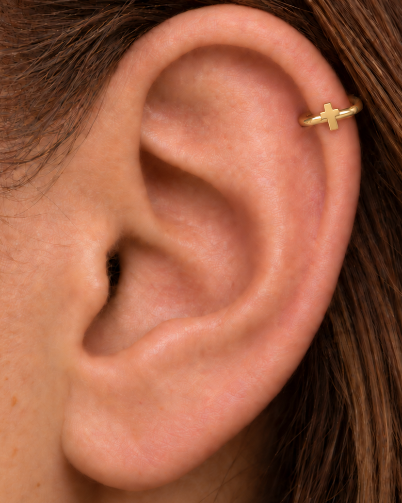 A polished cross gives the hoop a clean symbolic detail without stones, enamel or dangling parts. Made for fully healed helix piercings, it keeps the profile compact for an upper-ear stack while leaving the motif clearly visible. Handmade to order in 14ct solid gold, it fits naturally with clean, symbolic and understated styling rather than reading as a generic plain hoop.