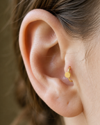 A simple circle motif keeps the design pared back, rounded and easy to mix with other jewellery. Made for fully healed tragus piercings, it adds a compact decorative detail without turning the piece into a dangling design. Handmade to order in 14ct solid gold, it fits naturally with simple, rounded and minimal styling rather than reading as a generic plain hoop.