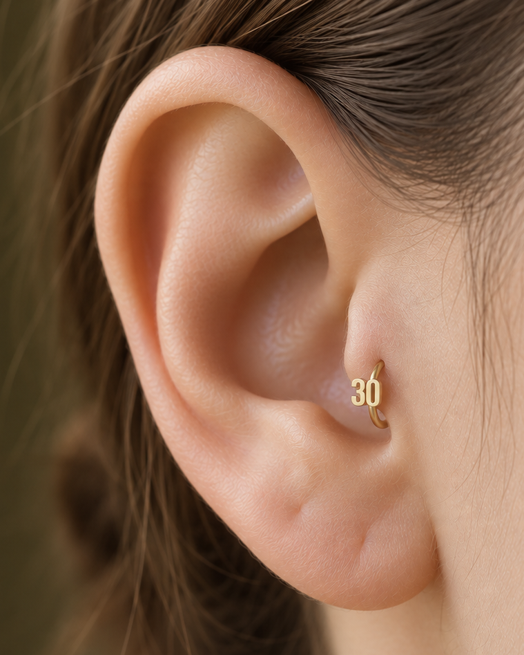 Choose one digit to give the hoop a small number-led detail with personal meaning. Made for fully healed tragus piercings, it adds a compact decorative detail without turning the piece into a dangling design. Handmade to order in 14ct solid gold, it fits naturally with personalised, number-led and meaningful styling rather than reading as a generic plain hoop.