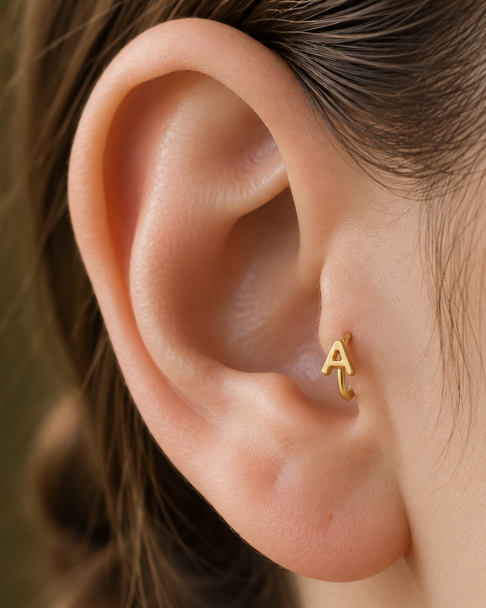 Choose one letter to turn the hoop into a small personalised piece with a clear initial-led focus. Made for fully healed tragus piercings, it adds a compact decorative detail without turning the piece into a dangling design. Handmade to order in 14ct solid gold, it fits naturally with personalised, meaningful and initial-led styling rather than reading as a generic plain hoop.