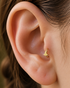 A tiny witch hat brings a playful witchy detail to the hoop without turning it into costume jewellery. Made for fully healed tragus piercings, it adds a compact decorative detail without turning the piece into a dangling design. Handmade to order in 14ct solid gold, it fits naturally with witchy, playful and Halloween-led styling rather than reading as a generic plain hoop.