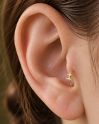 A graveyard-style cross gives the hoop a darker gothic reference that is distinct from the simpler cross design. Made for fully healed tragus piercings, it adds a compact decorative detail without turning the piece into a dangling design. Handmade to order in 14ct solid gold, it fits naturally with gothic, spooky and alternative styling rather than reading as a generic plain hoop.