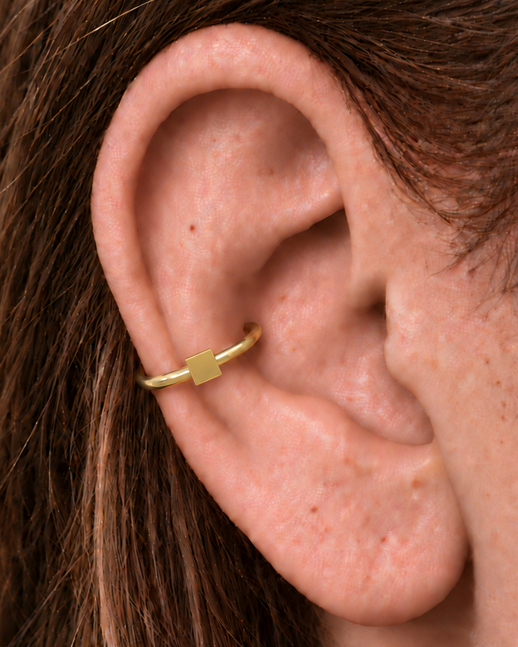 A small square motif gives the hoop a crisp, graphic finish while keeping the overall design minimal. Made for fully healed conch piercings, it pairs the larger hoop silhouette of a conch ring with a small fixed motif for a more distinctive ear stack. Handmade to order in 14ct solid gold, it fits naturally with crisp, geometric and minimal styling rather than reading as a generic plain hoop.